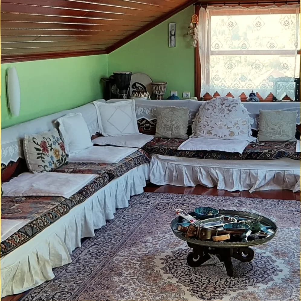 Çatı katında işlemeli minderlerle döşenmiş sedir köşesi